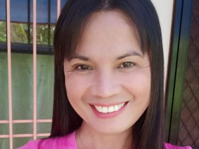 PatriciaMoore has smooth brown skin, long straight black hair, and is smiling with white teeth. She's wearing a pink shirt, and her brown eyes are looking at the camera.