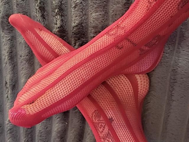 ElixirShanna's pink fishnet stockings with vertical stripes and lace patterns, crossed and overlapping, showing her bare ass through the see-through material.