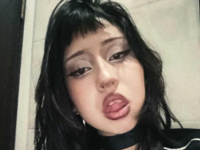 YumeLee heeft zwart, golvend haar, donkere eyeliner en glanzende, roze lippen, waarbij haar tong lichtjes uitsteekt. Ze draagt een zwarte choker en oorringen. Haar uitdrukking is verleidelijk..