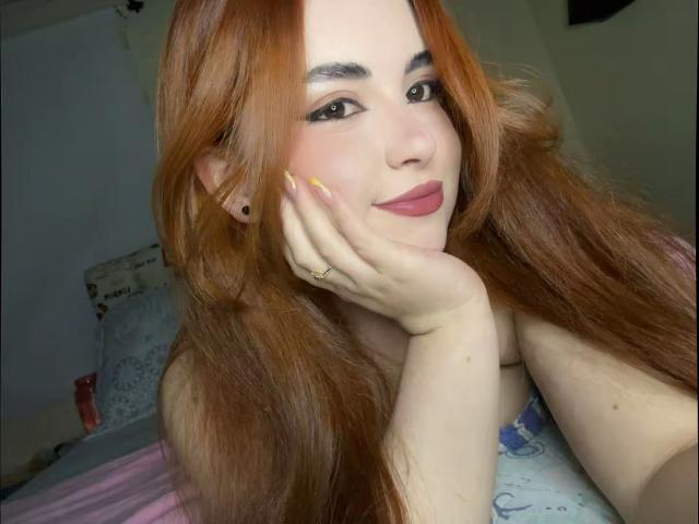 VicluX ha lunghi capelli rossi, occhi marroni ed è sorridente, con una mano appoggiata sulla guancia. Ha le unghie gialle e indossa un rossetto rosa. Il suo seno è parzialmente visibile..