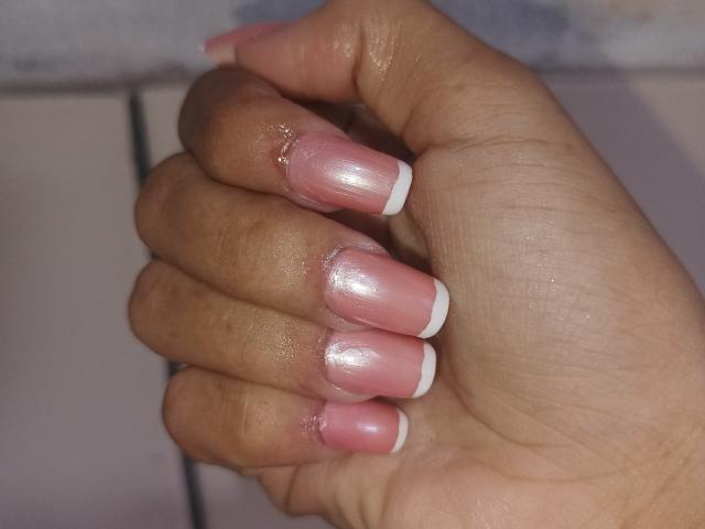 AngelRosa69's hand with shiny pink and white French-tip nails, slightly glossy with some oil, showcasing short, neat, and well-kept fingers. Boobs are not visible.