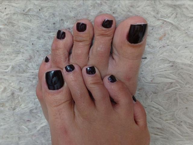 LailaCastillo's toes have shiny black nail polish, slightly uneven, with a few small chips. Her feet are slightly dirty, and her skin is light with some redness.