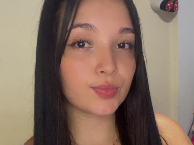 SarahGood has long black hair, light brown skin, and is pouting with pink lipstick. She's looking at the camera with small, dark eyes and slightly parted lips.
