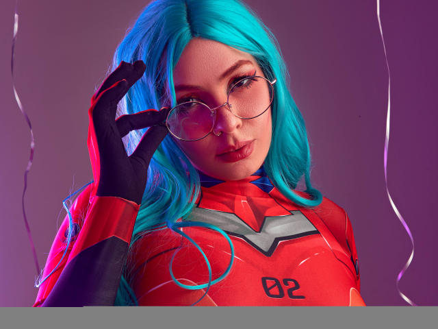 VanessaClose with blue hair, round glasses, red and black bodysuit, black gloves, adjusting glasses, purple and pink lighting, looking at camera, slightly parted lips, soft expression.