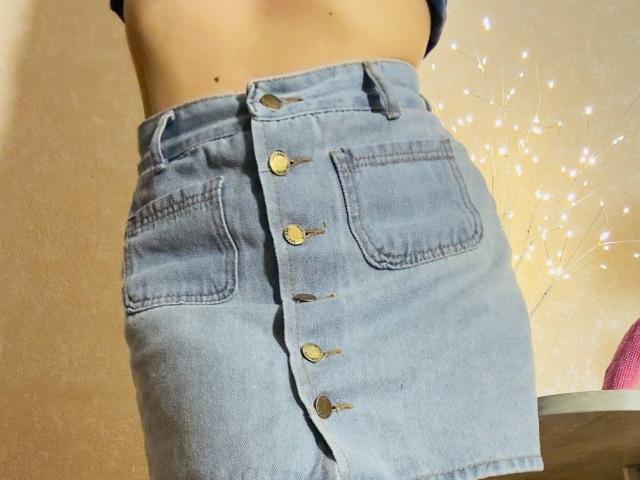 BalletSwan's blue denim skirt with brass buttons, showing her bare midriff and two front pockets. Skirt sits high on her waist, emphasizing her ass.