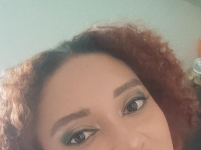 El rostro de VioletaSwitch, con cabello castaño rizado, delineador de ojos verde y ojos marrones. Sus cejas son oscuras y bien definidas. Su piel es de color marrón claro. Está mirando ligeramente hacia arriba..