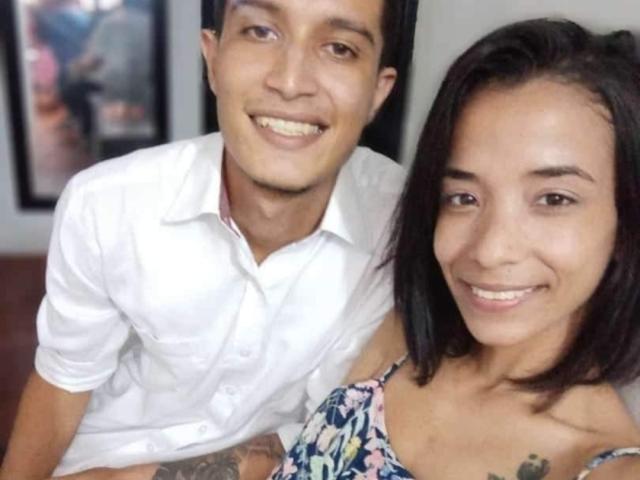 AlejoyMaria with short black hair, smiling, wearing a floral dress, next to AlejoyMaria with black hair, wearing a white shirt, both smiling. Tattoo on AlejoyMaria's arm visible.