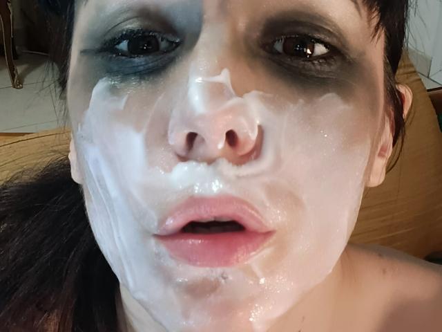 OrianaLaFrancaise's face covered in thick white cum, with her black eyes looking slightly to the side, and her pink lips parted. She has dark hair and a pale skin tone.