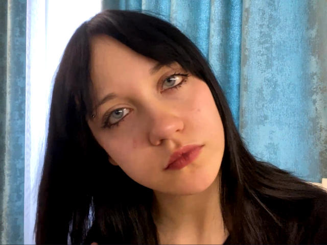 SantinaSahm heeft bleke huid, zwart steil haar, blauwe ogen met lange wimpers en een kleine neusring. Haar volle lippen zijn lichtroze. Ze kijkt vooruit met een neutrale uitdrukking..