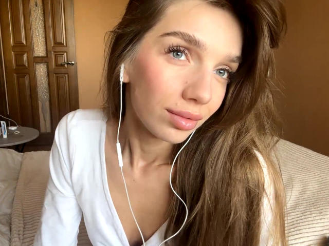 PortiaKomer ha lunghi capelli castani, occhi azzurri, labbra rosa e auricolari bianchi nelle orecchie. Indossa una maglietta bianca ed è molto carina, con un leggero sorriso..
