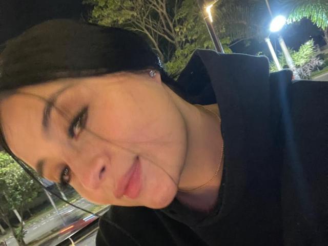 AnnyBentleii a les cheveux foncés, la peau claire, et porte un sweat à capuche noir. Elle a un léger sourire, on peut apercevoir de petites boucles d'oreilles, et ses lèvres ont un léger brillant. C'est la nuit..
