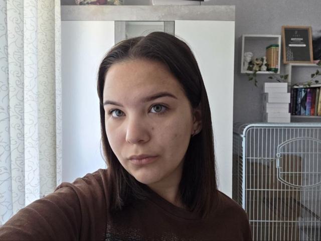 LaneTubman heeft bruin haar, een lichte huid, groene ogen en een serieuze uitdrukking. Ze draagt een bruin shirt, en op de achtergrond staat een metalen kooi..