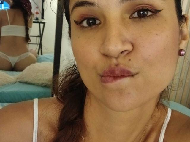 AmeliaBlond ha labbra piene, occhi marroni e sopracciglia scure. Indossa un reggiseno e uno slip bianchi, e il suo sedere è visibile in uno specchio. I suoi capelli castani sono raccolti in una coda di cavallo..