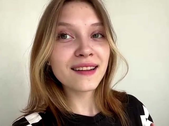 VeraBrabazon tiene el cabello castaño claro, ojos verdes y una ligera sonrisa. Lleva una camisa negra y blanca con diseños blancos en las mangas. Su trasero no es visible..