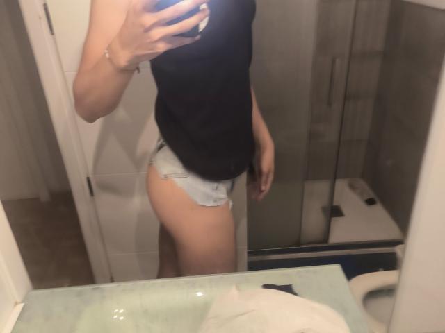 La selfie de Teronn la muestra con una camiseta negra sin mangas y unos pantalones cortos vaqueros azules claros y deshilachados, con su teléfono cubriendo su rostro. Su trasero es visible, reflejado en un espejo..
