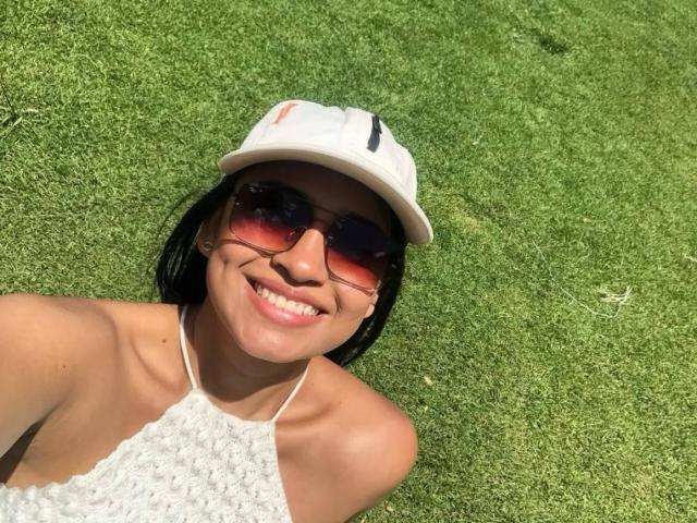 Hanna Harper mit voller Lippe, dunklem, glattem Haar und dezentem Make-up, die leicht nach oben schaut, wobei ihre Nase leicht zusammengekniffen ist, und die einen niedlichen, verspielten Ausdruck zeigt..