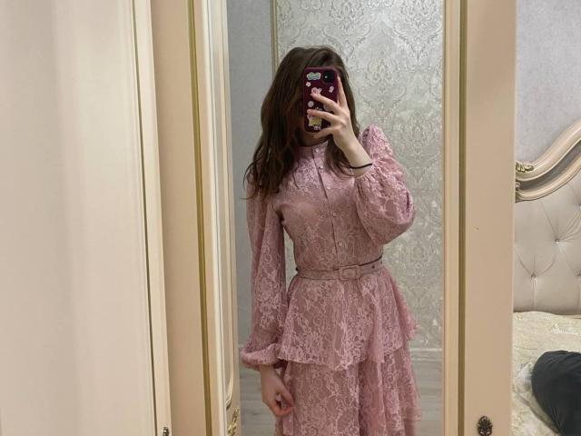 LiliaBilka in a pink lace dress, holding a phone with a floral case, covering her face, standing in front of a mirror, showing her tits and ass.