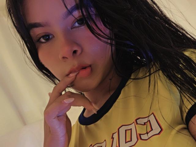 Yurimy with wet black hair, pouty lips, and finger in mouth, wearing a yellow sports jersey, has a cute and sexy face, showing off soft skin and a sexy look.