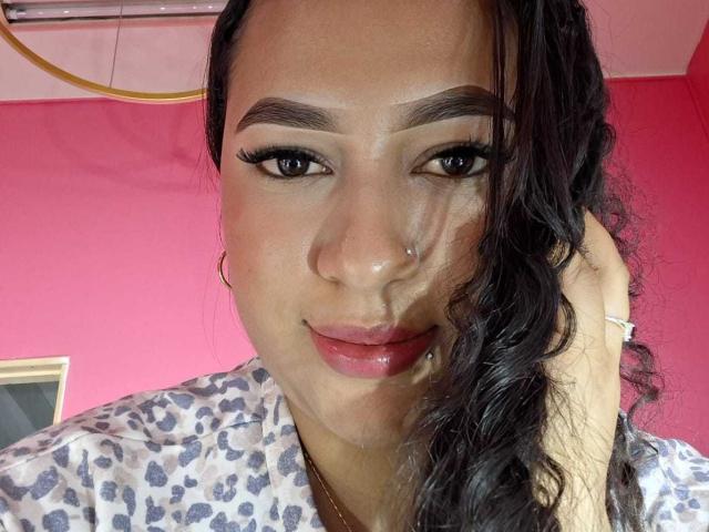 SoftLatina ha gli occhi marrone scuro, le sopracciglia folte, i capelli lunghi e neri ondulati e un piercing al naso. Indossa una camicia con la stampa di leopardo, ha il rossetto rosa e un leggero sorriso..