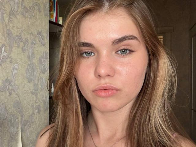 KristianSeidel heeft bleke huid, groene ogen en volle, roze lippen. Ze heeft lang bruin haar met blonde highlights, een beetje rommelig. Ze kijkt recht in de camera met een neutrale uitdrukking..