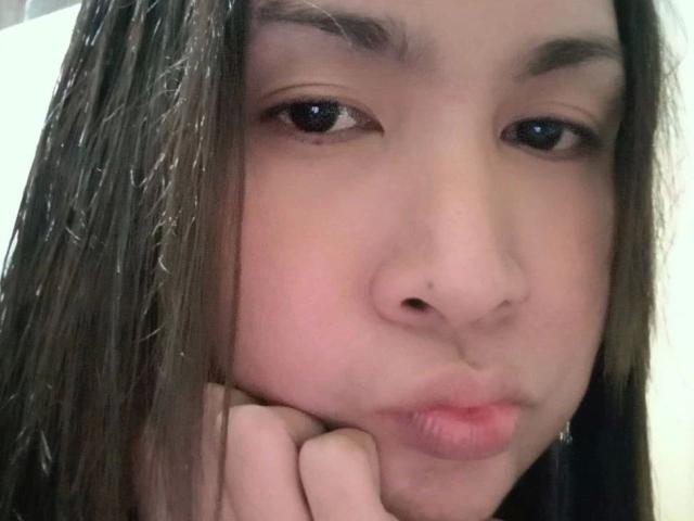 MISSKINKYWILD-hot's puffy ass-face, brown eyes half-closed, long wet brown hair, resting chin on hand, pinkish skin, small nose, slightly parted pink lips, looking bored.