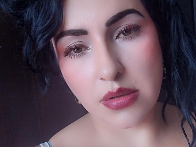 LuluFrancaise tiene el cabello oscuro y rizado, ojos marrones y labios rosados y brillantes, con un ligero brillo en su rostro. Sus cejas son gruesas y lleva un maquillaje muy discreto..