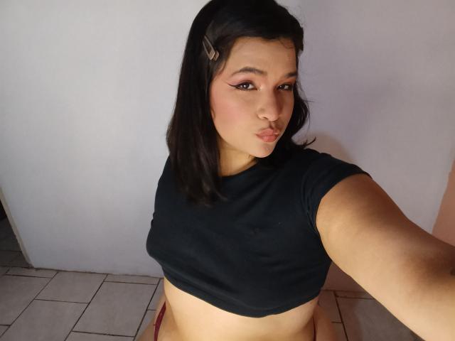 AntonelaPark has medium brown skin, black hair with a hair clip, wearing a black crop top, showing her tits, pouty lips, and pink eye makeup in a selfie.