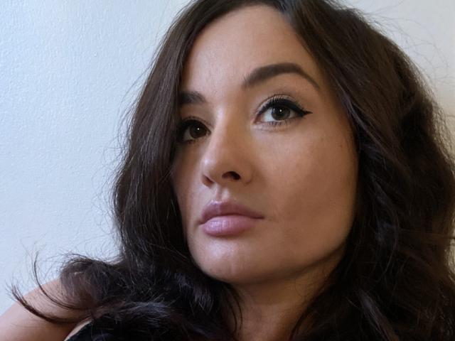 Dionisia heeft een medium bruine huid, lang, golvend donkerbruin haar en volle, roze lippen met subtiele make-up. Ze heeft een serieuze, lichtjes fronsende uitdrukking. Borsten zijn niet zichtbaar..