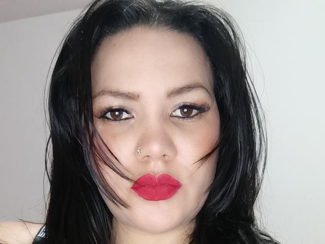 Pherlla a les cheveux noirs, les yeux marron, du rouge à lèvres et un petit piercing au nez. Ses lèvres pulpeuses sont légèrement retroussées, et son maquillage comprend de longs cils foncés..