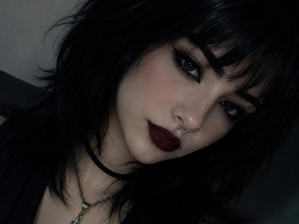 Leh69 ha i capelli neri e disordinati, un ombretto scuro, rossetto rosso, un piercing al naso e una collana a catena. Leh69 ha sopracciglia scure e folte e una pelle chiara, che sono molto evidenti. Le labbra di Leh69 sono piene..