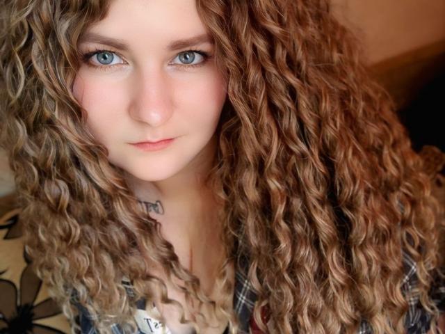 MinistraX heeft krullend blond haar, blauwe ogen en een tatoeage op haar nek, en draagt een geruite blouse. Haar borsten zijn klein, en haar gezicht is licht met een subtiele blos..