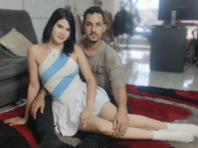 Jade y Bob, con cabello negro, senos pequeños, vestidas con un top de tirantes azul y blanco a rayas y una falda blanca, sentadas sobre una alfombra roja y negra, al lado de Bob, que tiene el cabello corto..