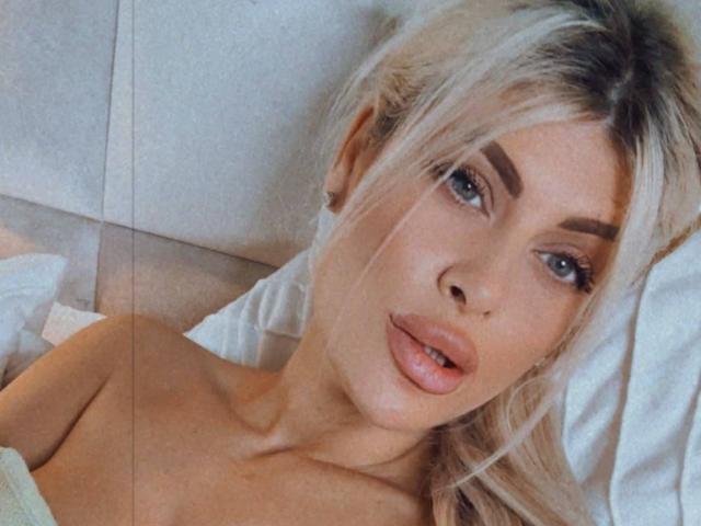 SalmaRoze ha i capelli biondi, gli occhi azzurri, labbra piene e rosse, ed è sdraiata senza indumenti superiori, con dei cuscini bianchi. I suoi capezzoli non sono visibili. Sembra sexy e leggermente seducente..