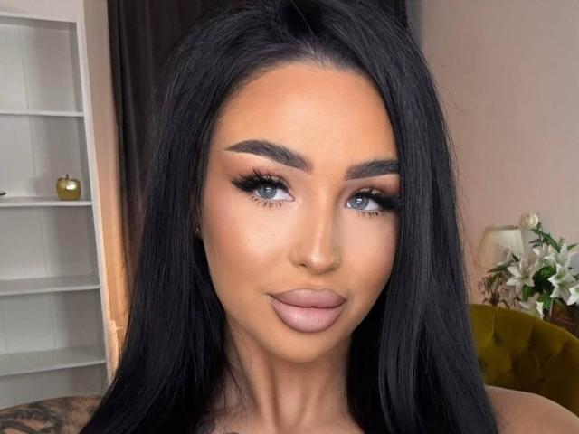 CelesteNyx a de longs cheveux noirs, des yeux bleus, des sourcils épais et du rouge à lèvres rose. Elle regarde légèrement vers le haut avec un sourire subtil, et porte un eye-liner et du mascara foncés..