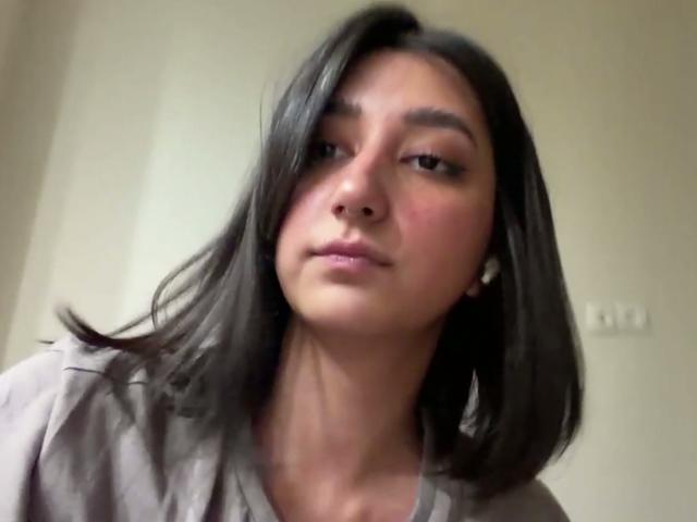 Heike Carchi, com cabelo preto na altura dos ombros, olhos castanhos, bochechas rosadas e um leve sorriso, vestindo uma camisa cinza, em um selfie tirada de baixo..