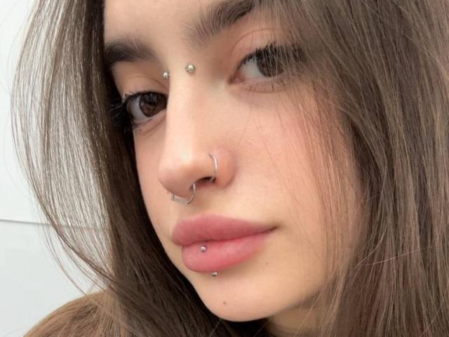 Ammaless a un anneau au nez, un piercing au septum et un piercing à la lèvre inférieure. Elle a les cheveux bruns, des lèvres roses pulpeuses et des yeux bruns avec de longs cils..