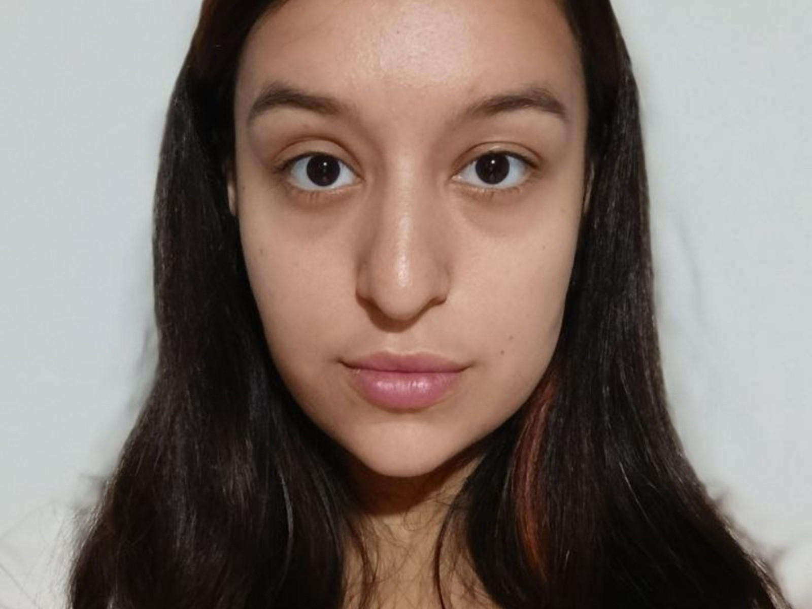 LinnRamsier a une peau brun clair, des yeux marron foncé et des cheveux noirs et lisses. Elle regarde directement l'appareil photo avec une expression neutre et des lèvres légèrement rosées..