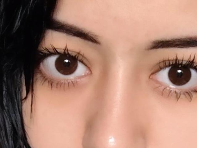 Los ojos marrones de Jettie Korczynski, con largas pestañas oscuras, cejas ligeramente arqueadas y piel clara. Tiene el cabello negro en el lado izquierdo. Está mirando fijamente..