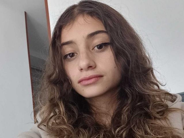 Katalina Laurent hat welliges, braunes Haar, helle Haut und blickt mit einem leichten, entspannten Lächeln in die Kamera. Sie trägt ein beiges Oberteil und hat einen neutralen Gesichtsausdruck..