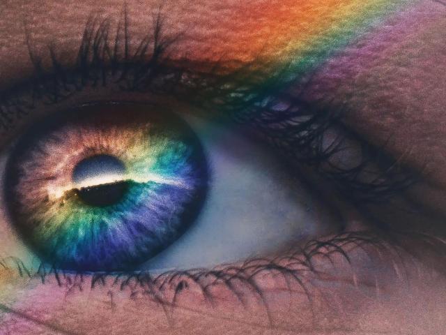 L'œil de GeorgTest-hot est coloré, avec des rayures arc-en-ciel, un iris bleu-vert et violet, et une pupille noire brillante, entouré de cils noirs et d'une peau rosée..