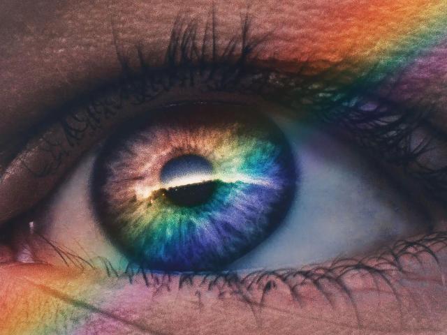 Het oog van GeorgTest-hot is een kleurrijke, blauw-groene iris met regenboogkleurige accenten, met een zwarte pupil, omgeven door donkere wimpers en een licht textuurrijke, bruinachtige huid. De iris ziet er bijna onwerkelijk uit..