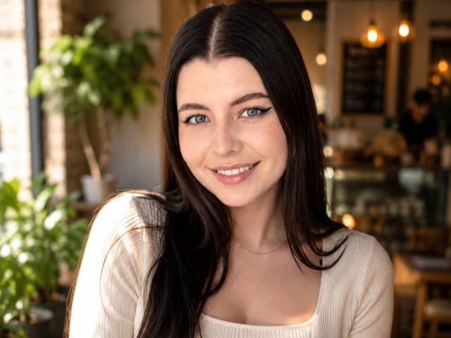 KizzyDepner ha lunghi capelli castano scuro, occhi azzurri e un sorriso carino. Indossa una maglia beige a coste che mette in mostra il suo seno piccolo, con un trucco leggero e un aspetto naturale..