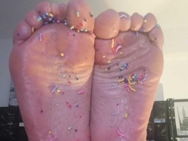 ZarayFeet's dirty soles, covered in colorful sprinkles, are up close with her toes slightly curled, showing wet and sticky textures.