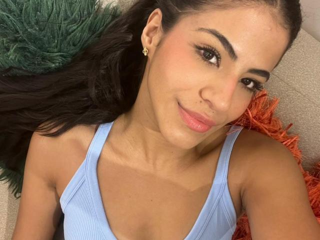 EvaGate ha la pelle abbronzata, i capelli neri e indossa una canotta azzurra, che mette in mostra il suo seno piccolo e un piccolo piercing al naso, con un sorriso carino e labbra rosa..