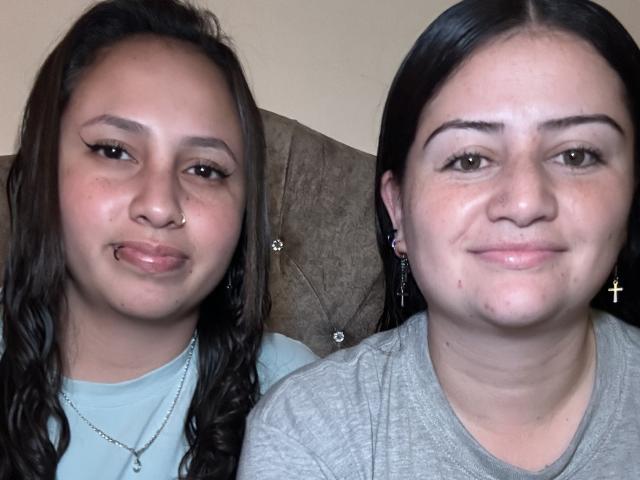 CandyAndHonney's face is a chubby ass with a nose ring, wearing a light blue shirt, next to CandyAndHonney with a cross earring, grey shirt, and a subtle smile.