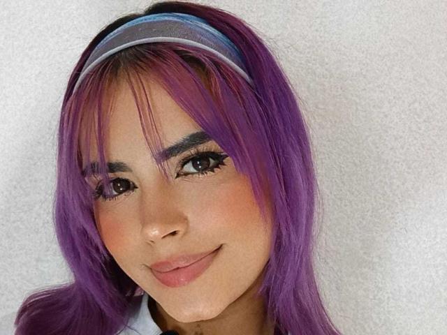 MafeRose ha i capelli viola, una fascia blu e un sorriso carino con labbra rosa. Ha gli occhi marroni ed è rivolta verso la fotocamera. Il suo seno non è visibile..