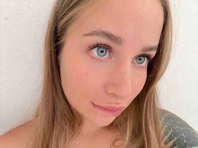 MirckyBlush tiene ojos azules, cabello castaño claro y una ligera sonrisa. Se pueden ver su pequeña nariz y sus labios rosados. Tiene un tatuaje en el hombro derecho..