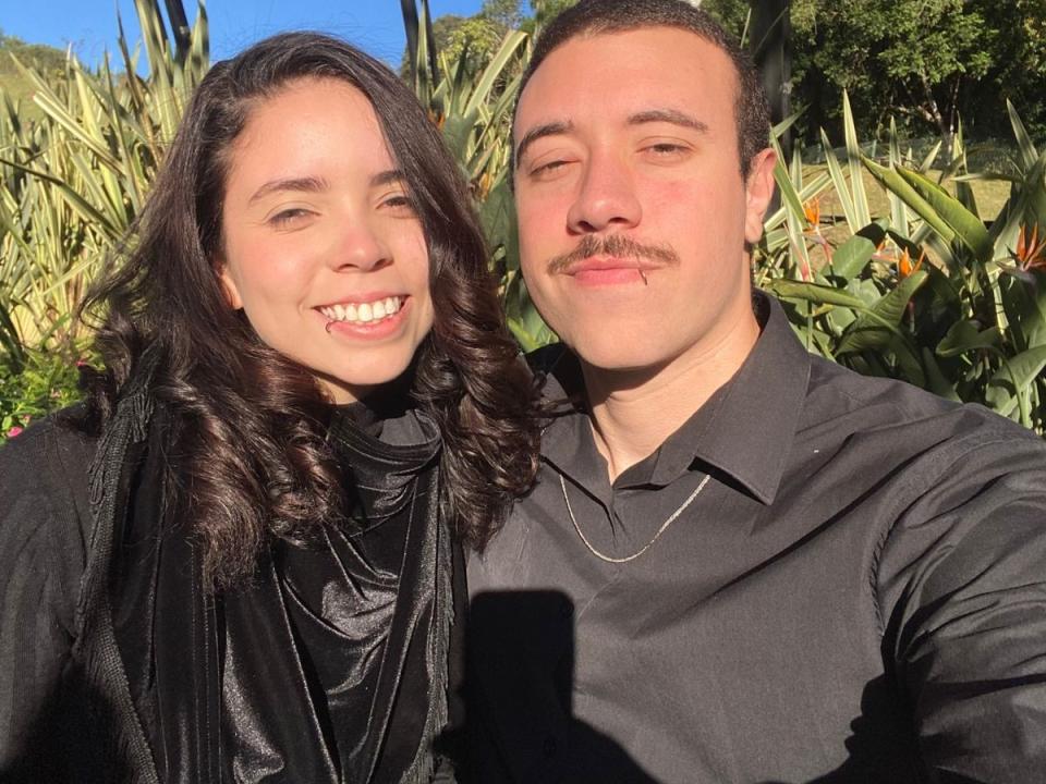 ObsidianCasal e ObsidianCasal con camicie nere, ObsidianCasal con capelli scuri ricci e una sciarpa nera, e ObsidianCasal con capelli corti e un baffo, sorridenti alla luce del sole..