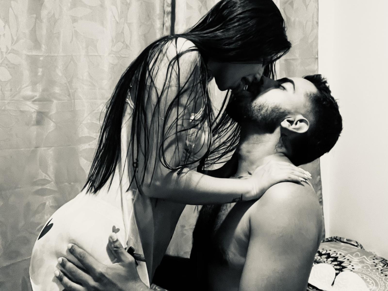 Annie e Nick, com longos cabelos escuros, nua, está inclinada sobre Nick, que está sem camisa, beijando-a. A mão de Nick está agarrada em suas nádegas, os seios de Annie pressionados contra o rosto de Nick. Foto em preto e branco..