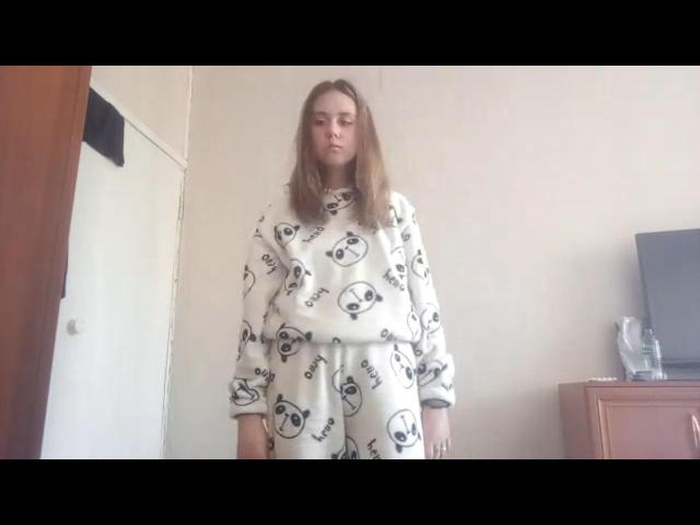 Cheyenne Moretta, con cabello largo y castaño, vestida con un conjunto de pijama blanco con estampados de calaveras negras y la palabra "amor", está de pie en una habitación, mirando hacia abajo con una expresión neutra..